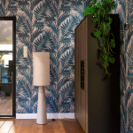 Woonkamer detail met zwart stalen deuren en blauw bladmotief behang