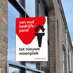 Sfeerbeeld makelaarsbord aan de ruit van een fabriek